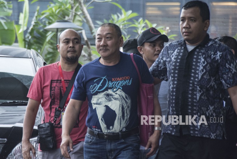 Dirut PT Sinar 99 Permai Wilhelmus Iwan Ulumbu (kedua kiri) dengan pengawalan petugas, tiba untuk menjalani pemeriksaan di gedung KPK, Jakarta, Senin (12/2).