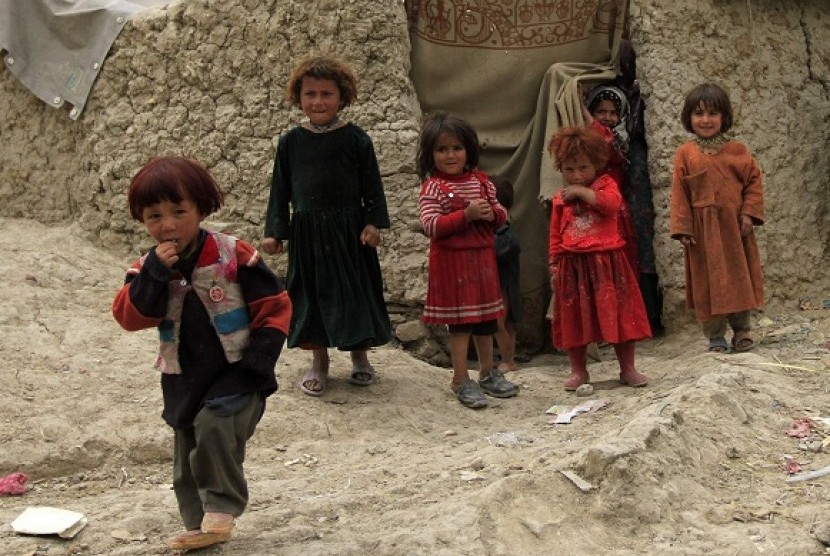 Displaced Afghan children stand near their shelter at a refugee camp in Kabul, May 9, 2012.   