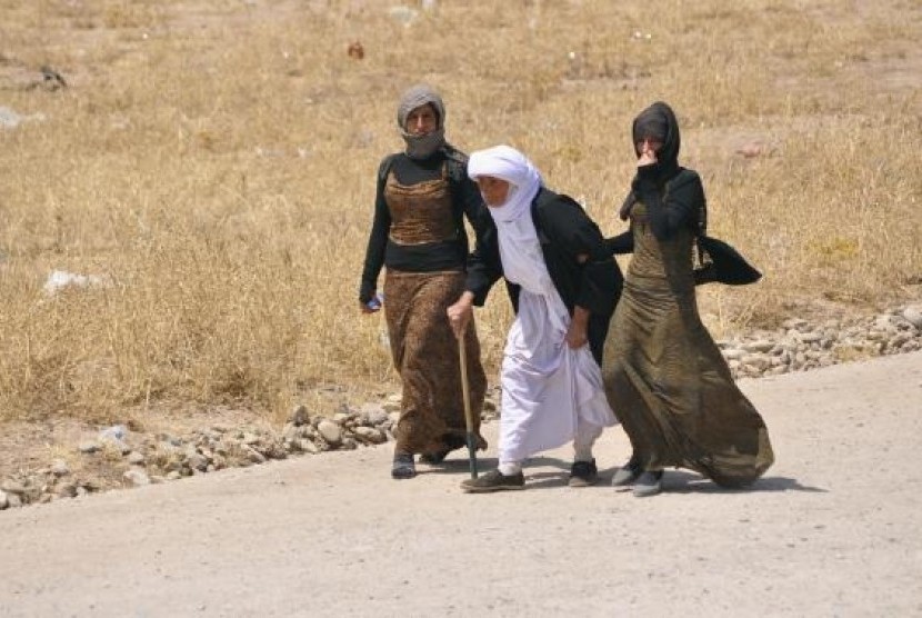 Displaced families from the minority Yazidi sect, fleeing the violence, walk on the outskirts of Sinjar, west of Mosul, August 5, 2014.