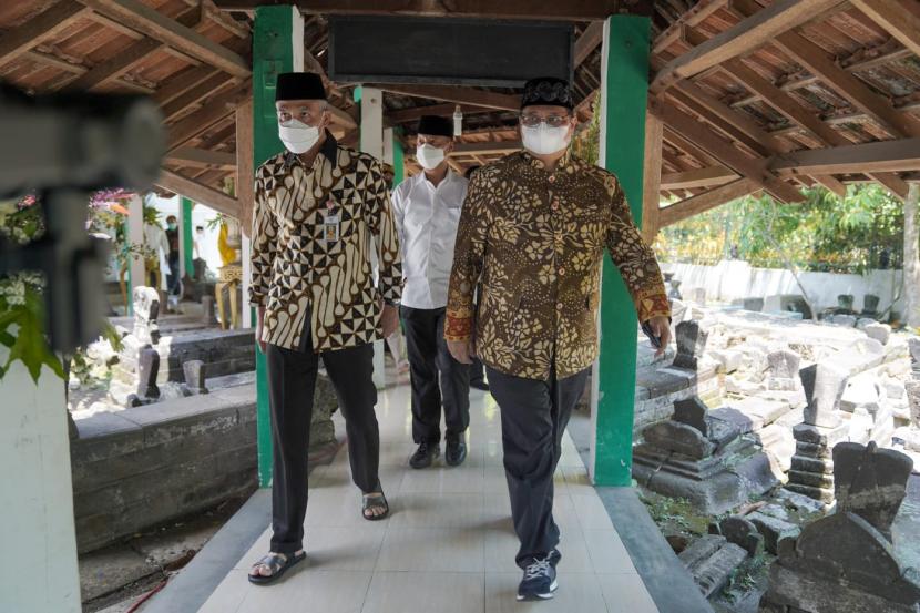   Menteri Koordinator Bidang Perekonomian Airlangga Hartarto (kiri) bersama Gubernur Jawa Tengah Ganjar Pranowo (kanan) saat mengunjungi makam Kiai Ageng Gribig di Jatinom, Klaten, Jawa Tengah, Jumat (24/9).