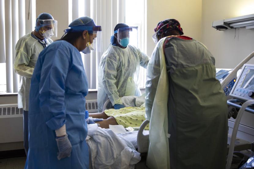 Dokter dan perawat mengelilingi pasien yang terpapar Covid-19 di Roseland Community Hospital, Chicago, Amerika Serikat, Selasa (28/4). AS Cetak Sejarah, Kematian Terkait Covid-19 Tembus 900 Ribu Jiwa