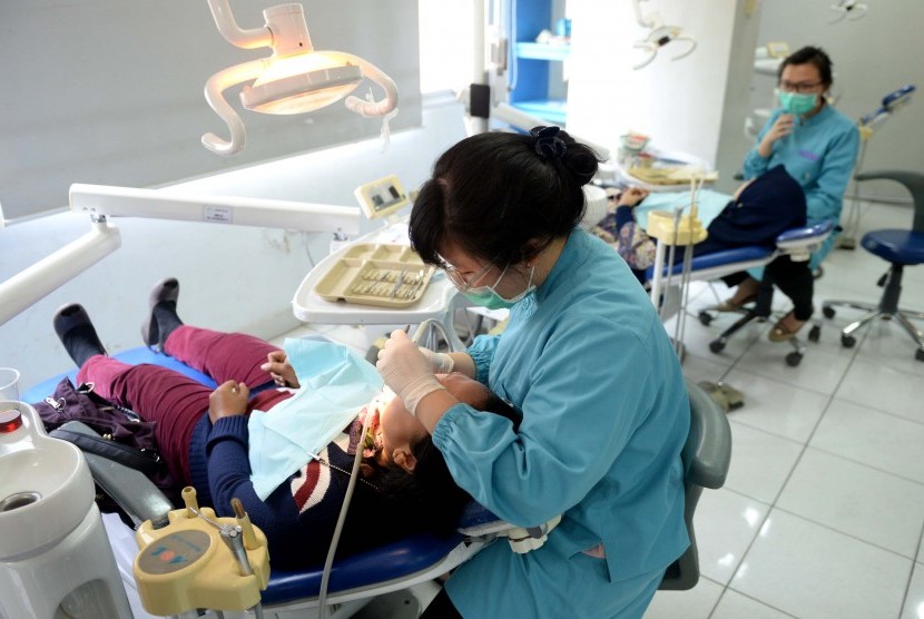 Dokter melakukan perawatan gigi gratis bagi masyarakat saat Bulan Kesehatan Gigi Nasional di Fakultas Kedokteran Gigi Universitas Indonesia, Jakarta, Selasa (22/9).Republika/Wihdan Hidayat