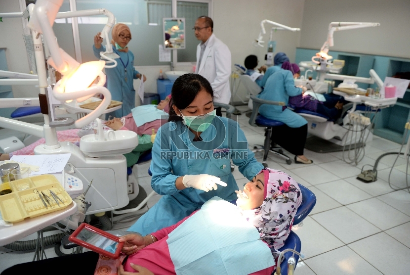  Dokter melakukan perawatan gigi masyarakat saat Bulan Kesehatan Gigi Nasional di Fakultas Kedokteran Gigi Universitas Indonesia, Jakarta, Selasa (22/9).