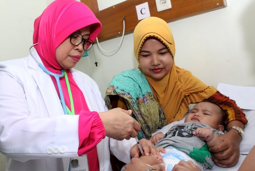 Dokter menyuntikkan vaksin kepada balita yang terpapar vaksin palsu saat melakukan vaksinasi ulang, di rumah sakit Rawalumbu, Bekasi, Jawa Barat, Selasa (26/7). 