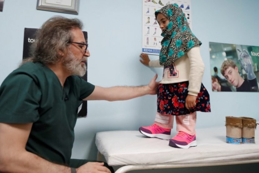 Dokter spesialis prostetik dari Turki, Mehmet Zeki Culcu memasang kaki palsu untuk gadis Suriah Maya Merhi di Istanbul, Turki..