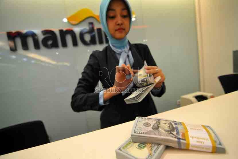 Dolar AS Melemah. Petugas menghitung mata uang Dolar AS di Bank Mandiri, Jakarta, Selasa (19/8). (Republika/ Wihdan).