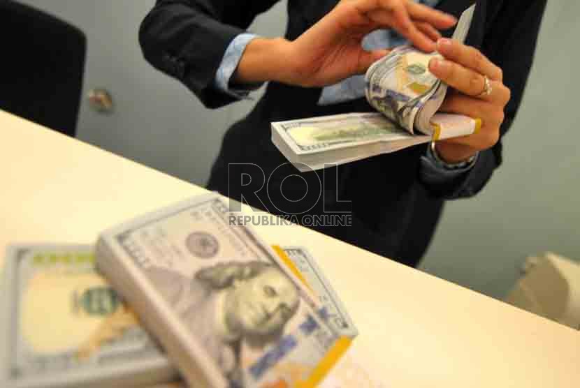 Dolar AS Melemah. Petugas menghitung mata uang Dolar AS di Bank Mandiri, Jakarta, Selasa (19/8). (Republika/ Wihdan).