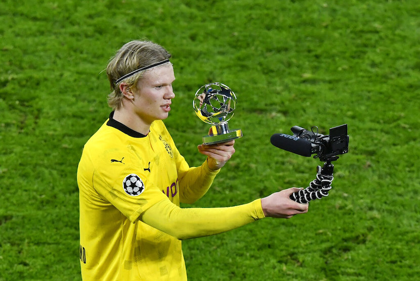 Dortmunds Erling Haaland films himself with a trophy for a man of the match after the Champions League, round of 16, second leg soccer match between Borussia Dortmund and Sevilla FC in Dortmund, Germany, Tuesday, March 9, 2021. 