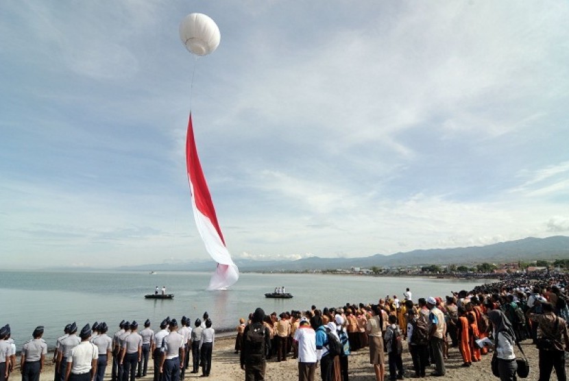 Dozens thounsands of people watch the Indonsian flag hoisting ceremony in Palu Bay in Central Sulawesi on Saturday, Dec. 14, 2013. The flag which is 1000 meter square emerges from underwater and this attraction is part of the Archipelago Day 2013.