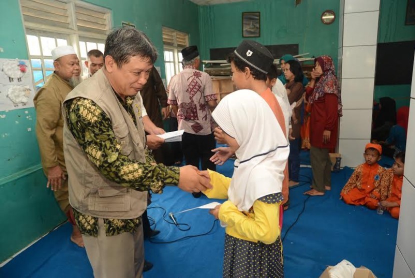 Dr. Ir. Agus Oman Sudrajat, M.Sc menyerahkan santunan untuk warga Balumbang Jaya