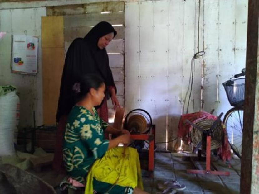 Dr Siti Nikmatin (berdiri), melakukan peninjauan proses pemintalan serat batang pisang kering menjadi tali untuk bahan kerajinan tangan.