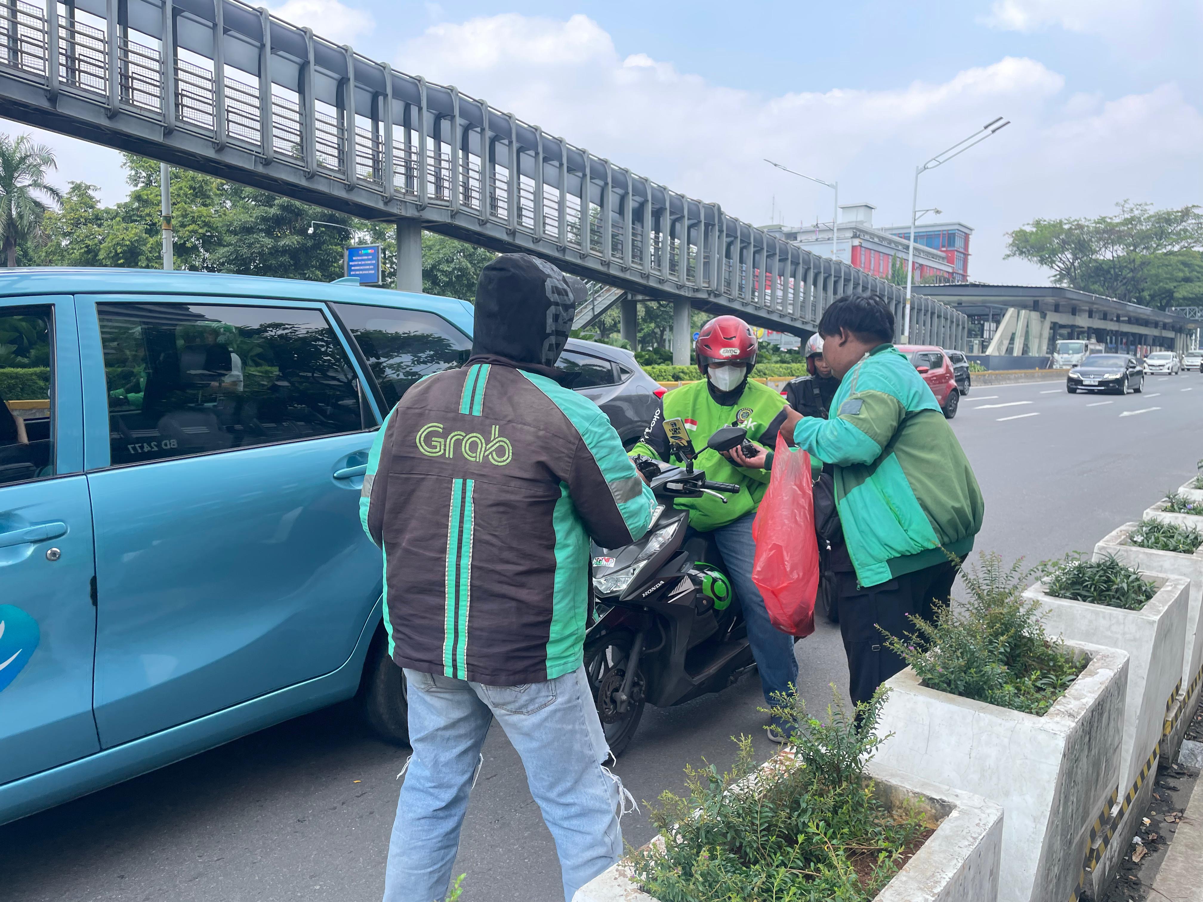 Driver ojol membagi-bagikan makanan kepada sesama driver yang lewat di jalan, Jumat (3/9/2025), yang dipesan pelanggan lewat aplikasi.