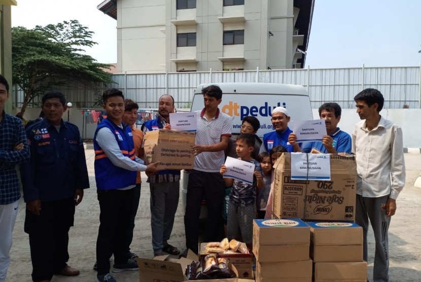 DT Peduli menyerahkan bantuan berupa roti dan air mineral bagi  pengungsi yang menetap sementara di Gedung Kodim Kalideres, Jakarta Barat.