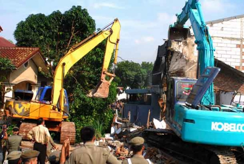  Dua alat berat digunakan untuk menghancurkan rumah ketika berlangsungnya penggusuran rumah warga di Kelurahan Jatinegara Kaum, Pulogadung, Jakarta, Rabu (22/5). 