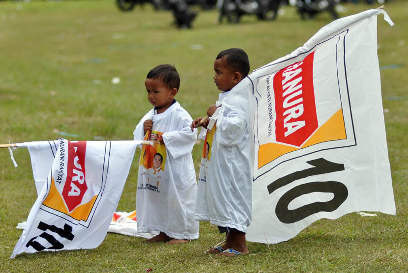 Dua anak balita mengenakan kaos dan membawa bendera parpol pada kampanye terbuka Partai Hanura di Lapangan Kujon, Borobudur, Magelang, Jawa Tengah, Jumat (21/3). 