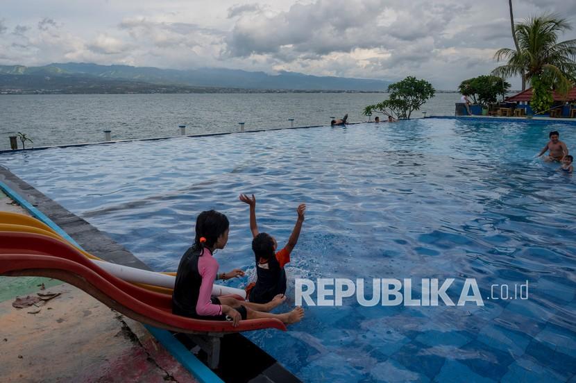 Dua anak bermain luncuran air kolam renang, (ilustrasi). Ada banyak destinasi seru di Indonesia untuk liburan bersama anak.