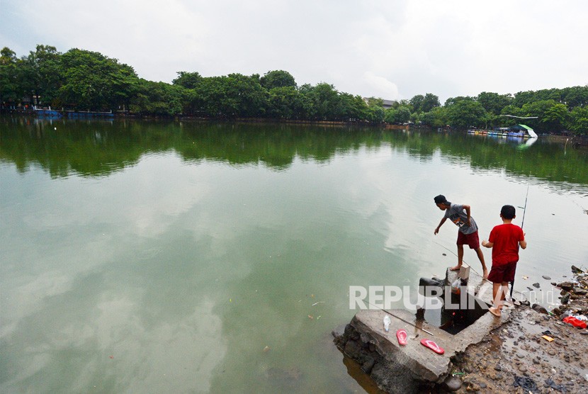 Dua anak memancing di Danau Sunter, Jakarta, Kamis (18/1). 