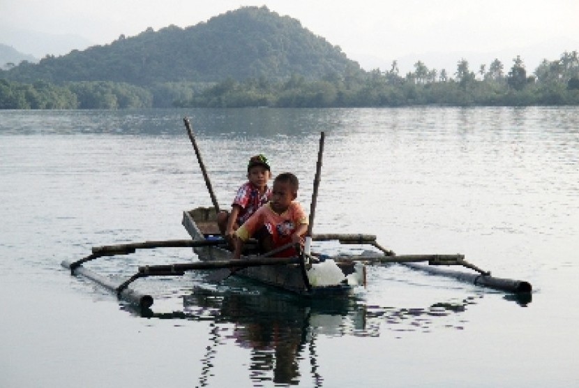   Dua anak mendayung perahu mereka ketika libur lebaran di Pantai Dusun Pemindangan, Desa Kampungbaru, Kec. Marga Punduh, Kab. Pesawaran, Lampung