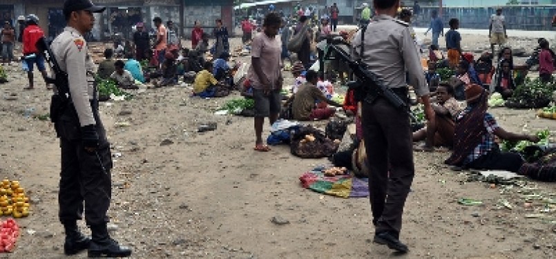 Dua aparat kepolisian berjaga di pasar Sinakma, Wamena, Papua, pasca bentrok antara warga di lokasi tersebut, beberapa waktu lalu.