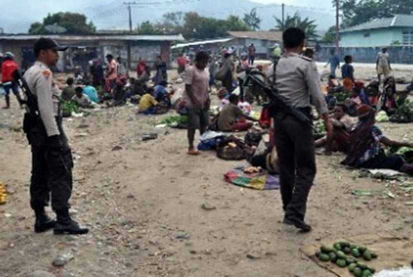 Dua aparat kepolisian berjaga di pasar Sinakma, Wamena, Papua, pasca bentrok antara warga di lokasi tersebut, beberapa waktu lalu.