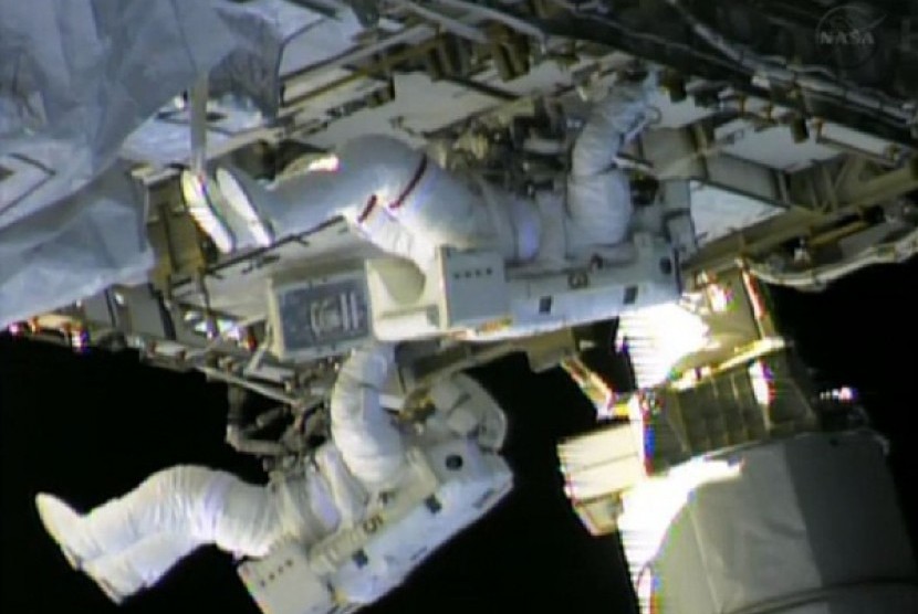 Dua astronot dari stasiun antariksa NASA, Chris Cassidy (atas) dan Tom Marshburn bekerja memperbaiki kebocoran di stasiun tersebut