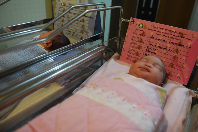 Perawat menggendong satu dari dua bayi yang baru lahir di RSIA Tambak, Jakarta, Senin (29/2).