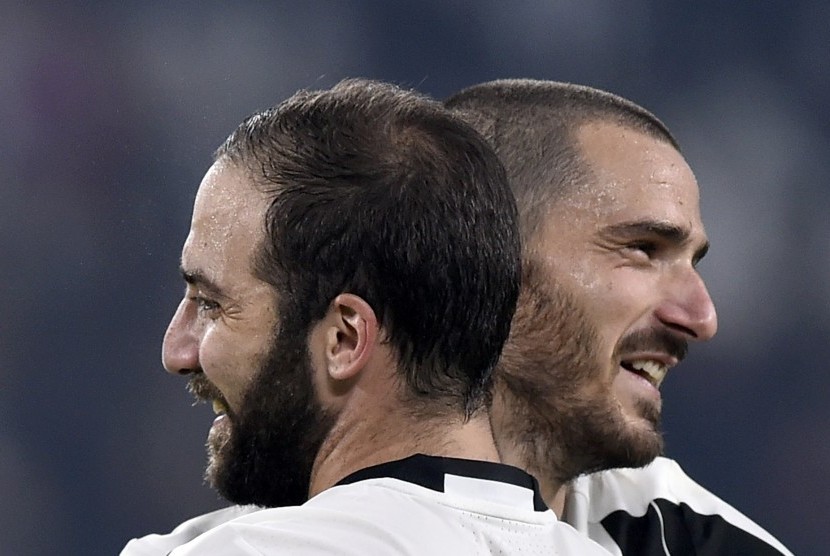 Dua bintang Juventus, Gonzalo Higuain dan Leonardo Bonucci berpelukan seusai laga Serie A lawan Napoli di stadion Juventus, Ahad (30/10) dini hari WIB. Juventus menang tipis 2-1 pada laga ini.
