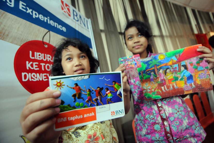 Dua bocah menunjukkan buku tabungan dan kartu BNI Taplus Anak bergambarkan karya nasabah di Kantor Pusat BNI, Jakarta, Jumat (2/5).