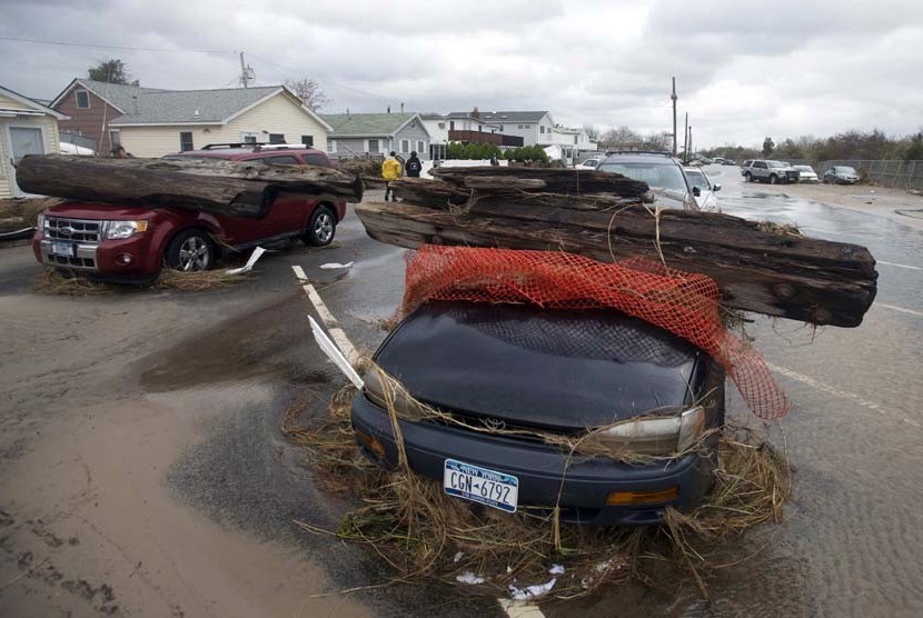  Dua buah mobil yang tertimpa pohon setelah diterjang Badai Sandy di New York, Selasa (30/10).    (Keith Bedford/Reuters)