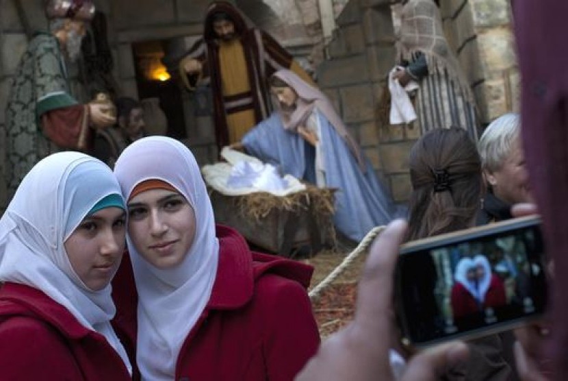 Dua gadis Muslim berfoto di perayaan Natal di Betlehem.