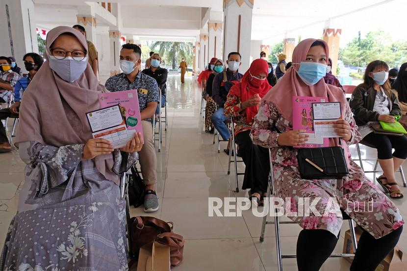 Dua ibu hamil menunjukkan surat vaksin dan buku kesehatan ibu dan anak saat vaksinasi COVID-19 bagi ibu hamil dan disabilitas di Lapangan DR Soepardi Sawitan, Mungkid, Magelang, Jawa Tengah, Senin (30/8/2021). Pemkab Magelang melalui dinas kesehatan melaksanakan vaksinasi COVID-19 bagi masyarakat rentan dengan sasaran 4.769 ibu hamil dan 9.902 penyandang disabilitas .