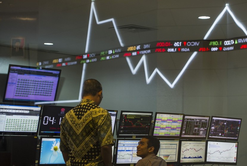Dua karyawan mengamati pergerakan Indeks Harga Saham Gabungan (IHSG) di Bursa Efek Indonesia, Jakarta, Jumat (22/4). 