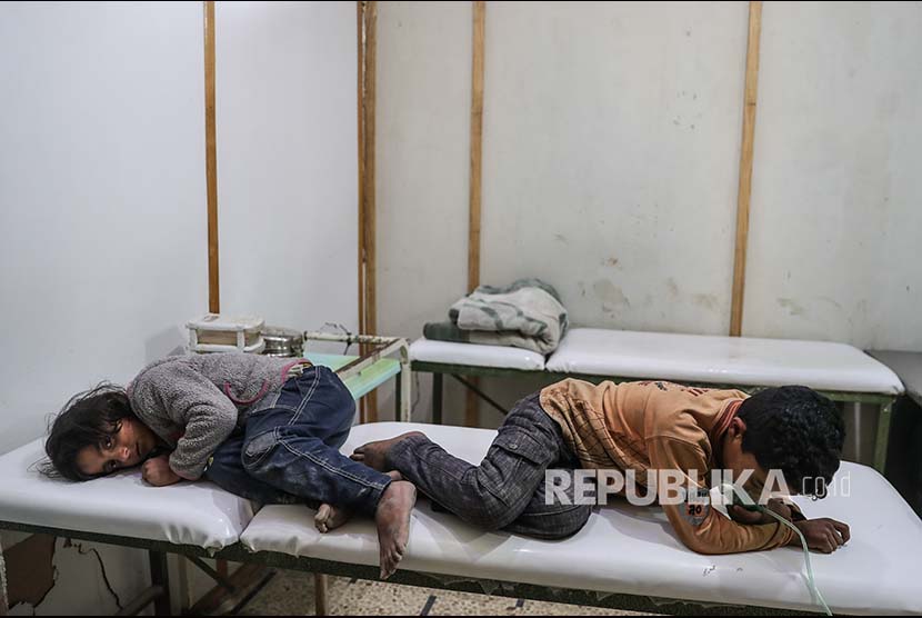 Dua orang anak memperoleh penanganan medis setelah terpapar gas beracun di Desa Shifunieh, Ghouta Timur, Suriah, Ahad (25/2).