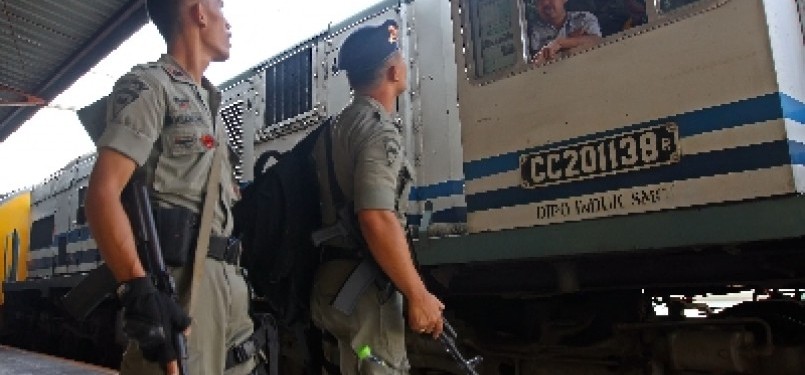 Dua orang anggota Brimob berkomunikasi dengan masinis di Stasiun Senen, Jakarta.