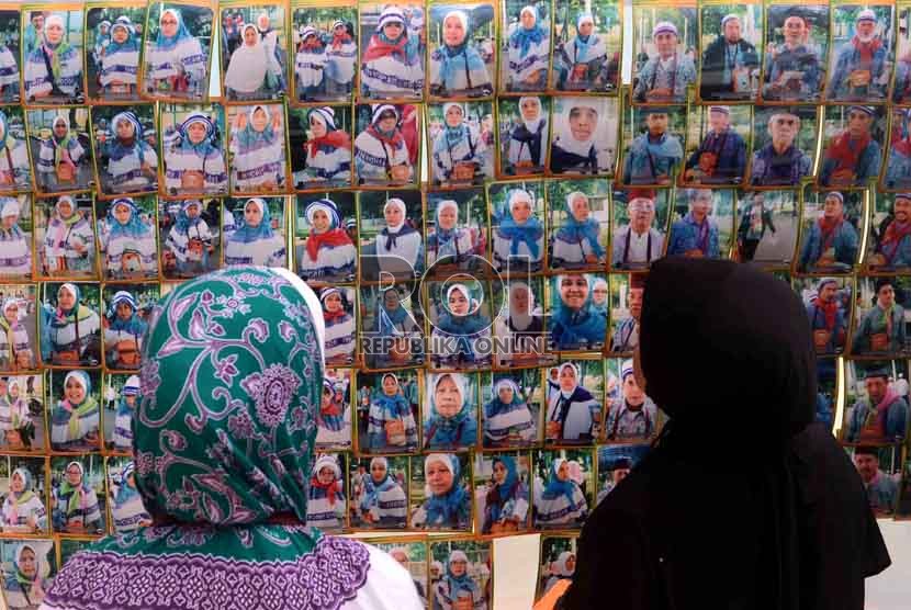  Dua orang jamaah calon haji kloter 29 asal DKI Jakarta mengamati foto yang dipajang di halaman Asrama Haji, Pondok Gede, Jakarta Timur, Rabu (10/10). (Agung Supriyanto/Republika)