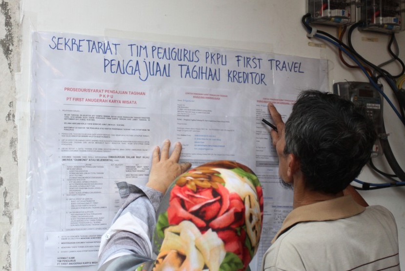 Dua orang korban penipuan First Travel melihat nama pada daftar di kantor tim pengurus penundaan kewajiban pembayaran utang (PKPU) di Grand Wijaya Center, Jakarta, Jumat (8/9).