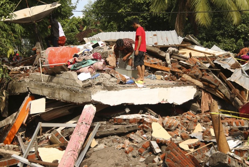 Dua orang laki-laki mencari sisa-sisa barang yang bisa diselamatkan salah satu rumah warga yang ambruk akibat diterjang banjir bandang di Desa Sepit, Keruak, Selong, Lombok Timur, NTB, Ahad (19/11).