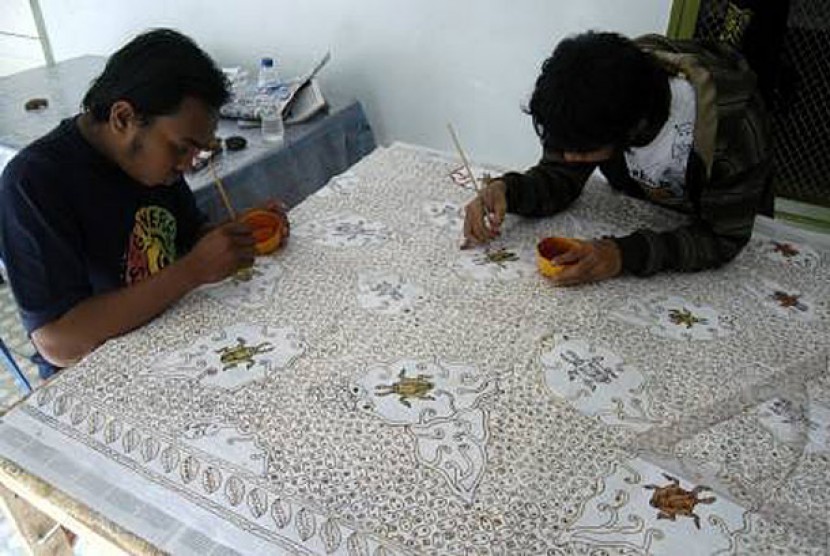 Dua orang pekerja melakukan proses pewarnaan batik tulis di Rumah Batik Jember, Jawa Timur, Kamis (25/11). Dalam sehari setiap pekerja mendapat upah mulai Rp.10.000 - Rp.45.000 tergantung dari motif dan tingkat kesulitan pengerjaan batik.