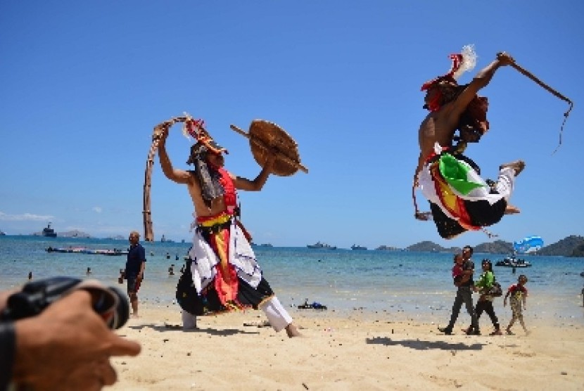  Dua orang penari memperagakan gerakan Tari Caci di Pantai Pede, Labuan Bajo, NTT tempat penyelenggaraan puncak Sail Komodo 2013