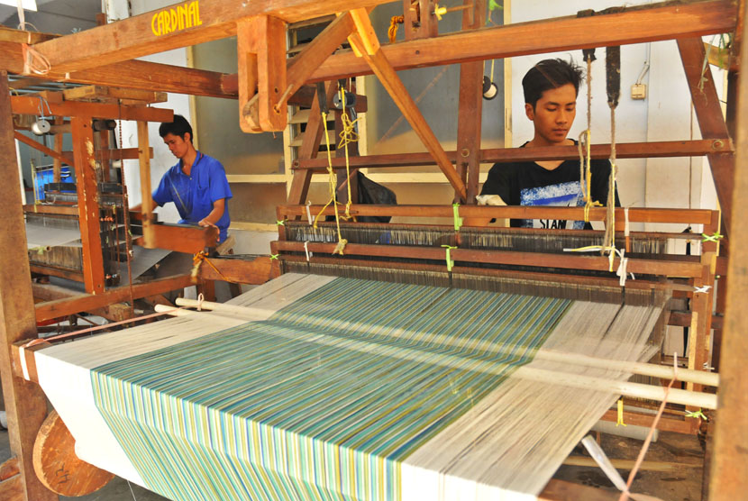 Dua orang perajin melakukan proses penenunan kain lurik banyumasan menggunakan alat tenun bukan mesin (ATBM) di Sentra Kerajinan Batik Mruyung, Banyumas, Jateng, 