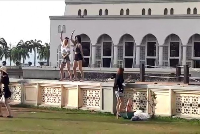 Dua orang perempuan diketahui menari di depan Masjid Kinabalu, Malaysia. 