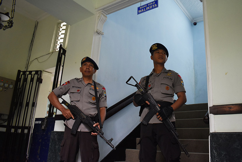 Dua orang personel Brimob bersenjata panjang menjaga tangga menuju ruang kerja Walikota Madiun Bambang Irianto saat tim Komisi Pemberantasan Korupsi (KPK) melakukan penggeledahan, di Madiun, Jawa Timur, Senin (17/10).