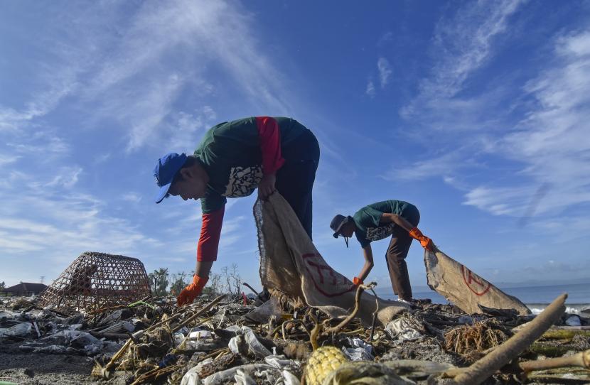  Upaya Mengurangi Sampah Plastik dengan Pendekatan Agama. Foto:  Dua orang relawan mengumpulkan sampah plastik  