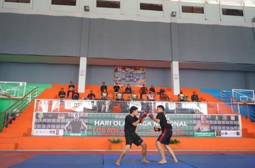 Dua orang remaja tengah melakukan latihan bela diri campuran (MMA) dalam ajang coaching clinic MMA sebagai bagian mengarahkan generasi milenial ikut kegiatan positif di Gor Merdeka Kota Sukabumi, Senin (5/9/2022).