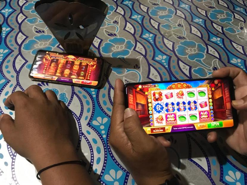 Dua orang sedang bermain game online berunsur judi higgs domino island di Padang, Rabu (3/8) 