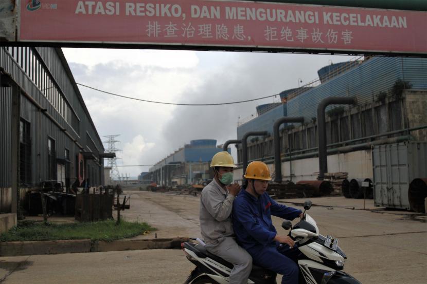 Dua orang tenaga kerja asing (TKA) melintas dengan sepeda motor di salah satu pintu masuk tangki penguapan milik PT Virtue Dragon Nickel Industri di Kecamatan Morosi, Kabupaten Konawe, Sulawesi Tenggara, Minggu (15/12/2019).