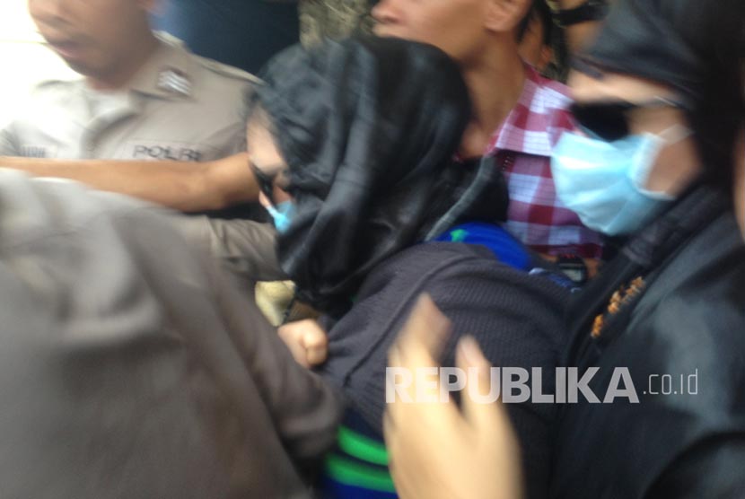 Dua orang terduga (memakai masker) penyalahguna narkoba yang ditangkap bersama Gatot Brajamusti, Ahad (28/8) tengah dibawa aparat Polres Mataram ke mobil yang akan dibawa ke Labfor Bali untuk pemeriksaan ulang tes DNA.