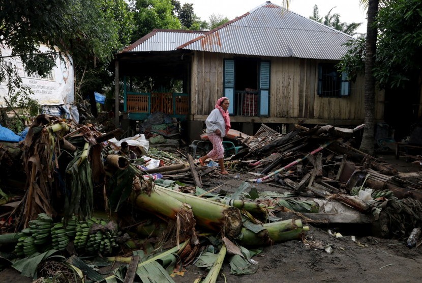 Dua orang warga berada di depan rumah mereka yang terkena dampak banjir yang terjadi di Jalan Imam Bonjol, Binjai, Sumatera Utara, Rabu (10/2). 