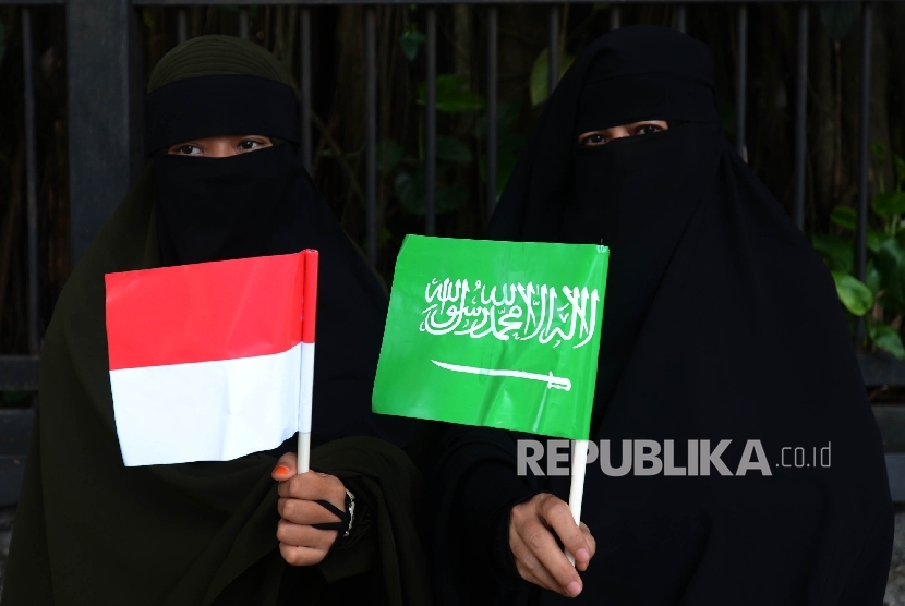 Dua orang warga bersiap untuk menyambut kedatangan Raja Salman di sekitaran Istana Bogor, Jawa Barat, Rabu (1/3).