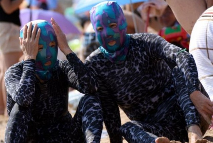 Dua Orang Warga Cina Tengah Berlibur di Pantai Berpakaian Renang ALa Alien 